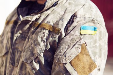 Ukrainian flag on uniform of soldier. Breaking news. Stop russian aggression. Stop war in Ukraine. Stay with Ukraine. Pray for Ukraine