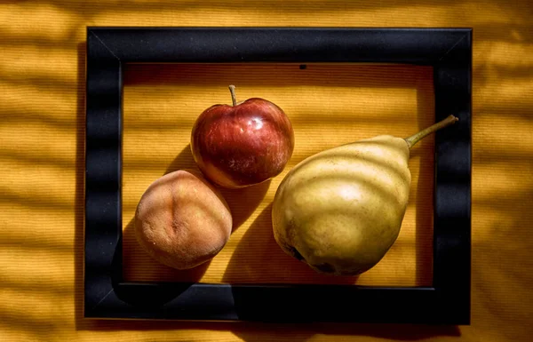 Творческая фотография фруктов: группа яблок, персиков и груш в рамке под модными тенями. Вид сверху. Витамины, концепция здорового питания — стоковое фото