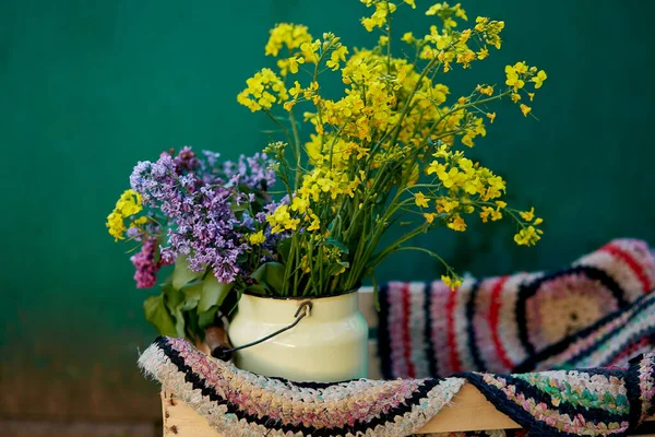 Vintage színes kézzel készített szőnyeg és tavaszi virágok öntözőkannában. Vidéki élet, kunyhó mag, kreatív rusztikus patchwork koncepció. Fénymásolási hely — Stock Fotó