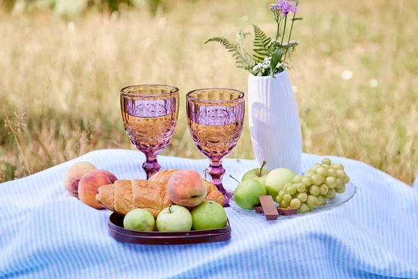 Ay çöreği, meyve, çikolata, üzüm ve ormanda bir bardak şarapla romantik yaz pikniği. Kır evi estetiği. Yaz havası