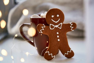 Atmosferik Noel arkaplanı - Bokeh 'li zencefilli kurabiye. Sıcak içecek ve marşmelovlu Noel süslemeleri. Estetik Noel atmosferi, ev konforu, sıcaklık konsepti