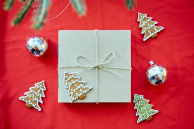  Hediye kutulu kart, el işi süsleme, köknar ağacı dalı ve Noel ağacı kurabiyeleri. Kırmızı kumaş konusunda iyi tatiller. Moda tarzı. Mutlu Noeller..
