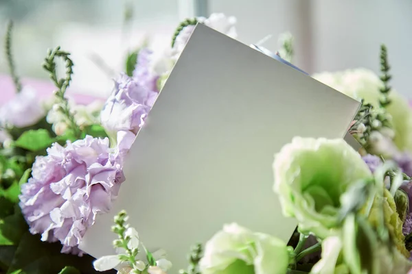 Mock up of post card close up with delicate big flowers bouquet of eustoma under day light. Copy space. Flowers delivery and present concept. High quality photo