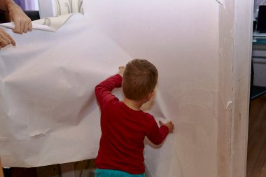 Baba ve oğul duvardaki eski duvar kağıtlarını söküyorlar. Odanın tadilatı için hazırlanıyor. Öğretmek evlat, mutlu ebeveynlik. Ev işleri işte. Baba oğul günü birlikte..