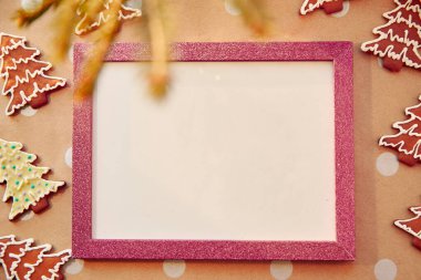 Pembe çerçeveli ev yapımı zencefilli kurabiye. Ev yapımı kurabiyeler. Bayramlık estetik kart. Noel atmosferi. Mutlu Noeller ve ev konforu. Yüksek kalite fotoğraf