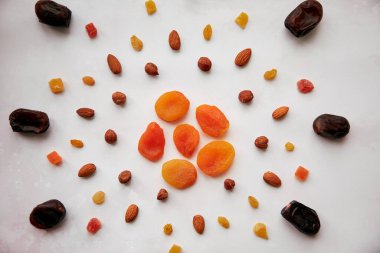 Güneşli, hurma, kurutulmuş kayısı, fındık, badem, şekerli meyve ve kuru üzüm şeklinde yaratıcı yiyecekler. Vegan doğal antioksidan yiyecekler, sağlıklı yiyecekler. Vejetaryen yemeği, sağlıklı beslenme konsepti