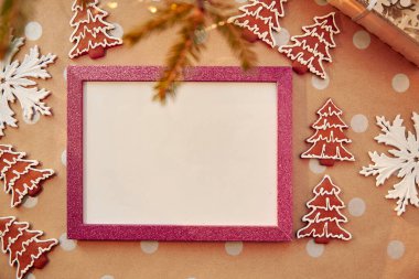 Pembe çerçeveli ev yapımı zencefilli kurabiye. Ev yapımı kurabiyeler. Bayramlık estetik kart. Noel atmosferi. Mutlu Noeller ve ev konforu. Yüksek kalite fotoğraf