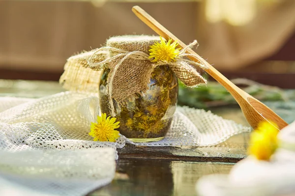 Natural organic tincture with fresh yellow wildflowers - dandelions. Homemade herbal organic dandelion tincture with wild flowers. Natural essence.