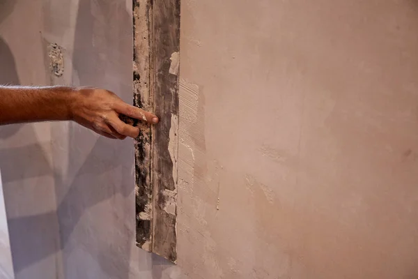 Home renovation: worker processes the wall with putty. True moment. High quality photo