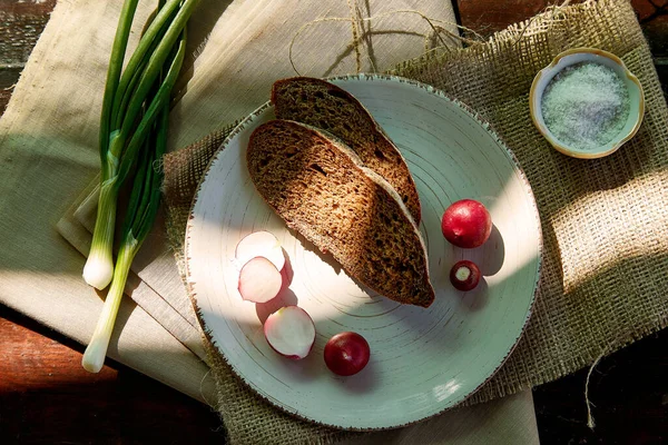 Sourdough bread with radish, salt and young onio. Eat out. Rustic food, snack in countryside. Rustic, organic eat out food. Summer picnic in countryside. Delicious recipe .