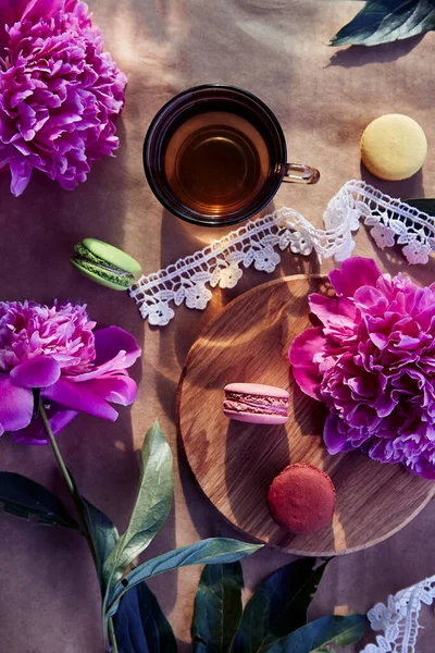 Helles Macarons Dessert Und Kräutertee Inmitten Blühender Rosafarbener Pfingstrosenblüten Unter — Stockfoto