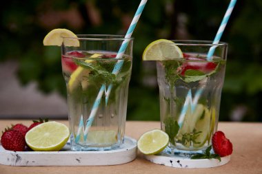 Yaz aylarında limon, kireç, nane ve çilek karıştırılmış su. Ferahlatıcı, diyet, detoks doğal güçlendirilmiş su. Nootroplu sert maden suyu. Sağlıklı doğal kokteyller. Yaz içecekleri..