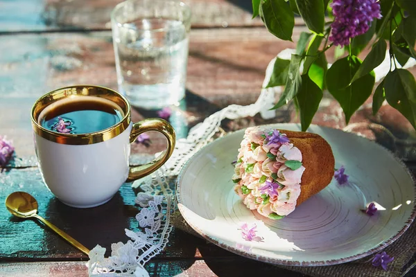 夏天的户外枝干与一杯咖啡 美丽的纸杯蛋糕 一杯水和灿烂的花朵 在阳光灿烂的日子里 带着夏日艳丽芬芳的花朵的小屋核心野餐 硬阴影 — 图库照片