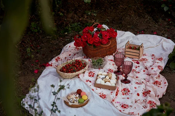 Masa örtüsü marşmelovlu, bezelyeli, çilekli, şarap kadehli, akşam parkındaki pembe güllerin arasında vişneli yaz pembe pikniği. Romantik yemek..