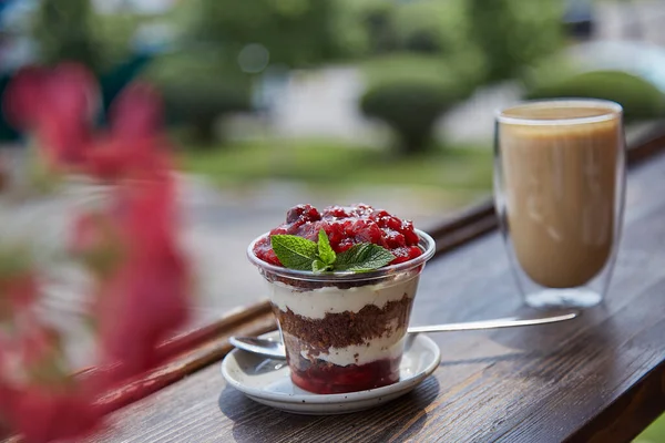 Natural lactose free, vegan, healthy layered, sugar free dessert with fresh fruits and berries. Glass of coffee, coffee time outside