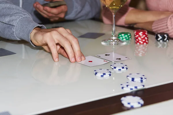 Laying out cards on the table in poker game. Players with dices and cards. Glass of champagne. Gambling concept. Candid moment. Poker background photography. Selective focus.