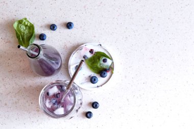 Yabanmersinli doğal bitkisel içecek, fesleğen özü ve yapraklar, sert gölgeler altında buz. İçecekleri tazeliyorum. Boşluğu kopyala.