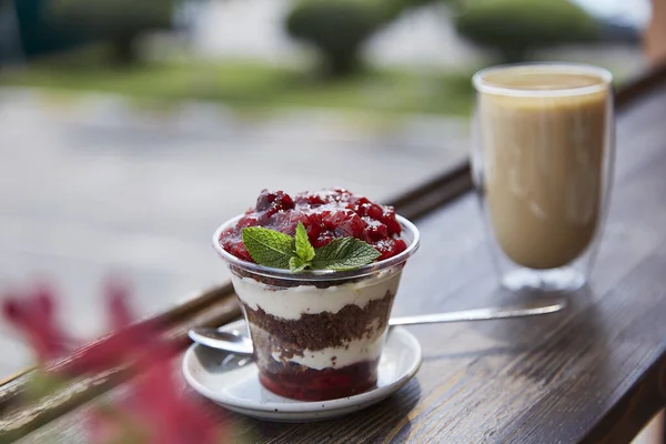 Natural vegan, healthy layered, sugar free dessert with fresh fruits and berries. Glass of coffee, coffee time in the terrace.