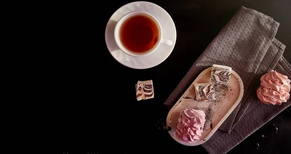Aesthetic cozy home breakfast. Cup of black tea and pink marshmallows with currant. Healthy sweets, sugar and gluten free natural dessert . Top view food with copy space. Extra wide banner.