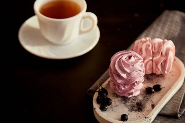 Aesthetic dessert - berry marshmallows with currant and cup of black tea. Autumn cozy atmospheric appetizer. Healthy sweets, natural food sugar and gluten free. Copy space.