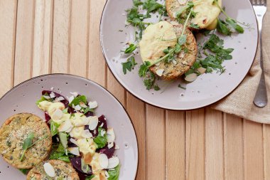 Tofu, bezelye filizi, otlar, badem gevreği, pancar salatası ve sebzeli vejetaryen keki. Terasta sağlıklı yiyecekler. İki kişilik kahvaltı..