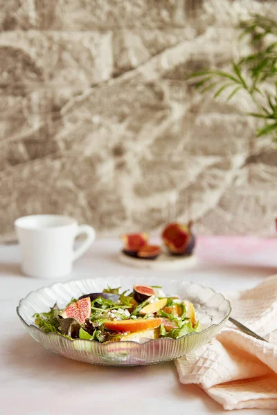 Aesthetic fresh salad of potato, arugula, grain cheese, peach and figs. Mediterranean healthy dish, vegan salad, easy recipe.