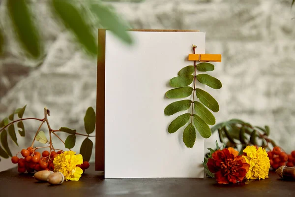 Vintage aesthetic autumn mock up. Crafting empty postcard, stationery card mock up among flowers and leaves. Atmospheric cozy home background.