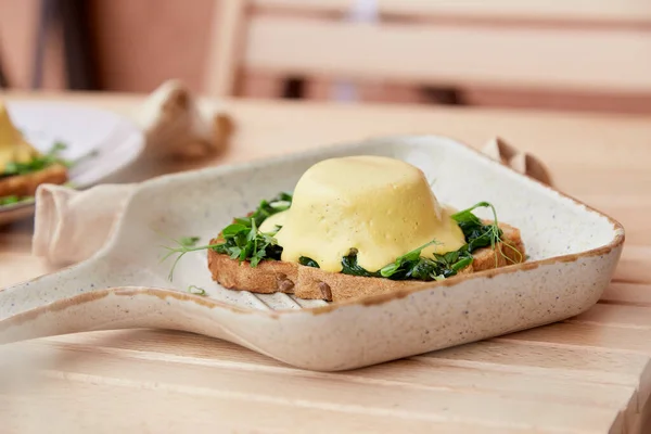 Vejetaryen alternatif yumurtalar, sebze soslu Benedict, tam tahıllı ekmek, füme tofu, taze soğan, yeşillik, bezelye filizi dışarıda.
