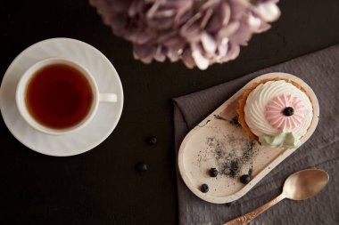 Atmosferik çay saati, kahvaltı. Frenk üzümlü kek ve bir fincan siyah çay, üst manzara. Uzayı kopyala Sonbahar iyi bir ruh hali.