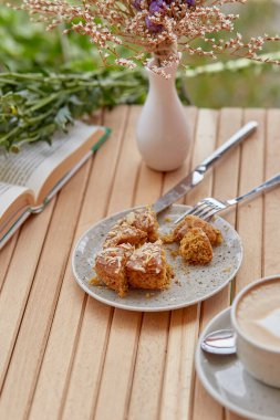 Estetik sonbahar havası. Kahve, kitap ve tatlı zamanı. Sonbahar süslemeleri arasında çörek ve kapuçino. Atmosferik öğle yemeği, suçluluk duygusu