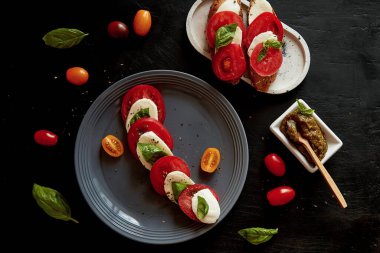 İtalyan caprese salatası, taze mozzarella, domates, fesleğen ve pesto soslu sandviç aperatifli caprese salatası. Manzaralı yemek. Kırsal klasik aperatif.