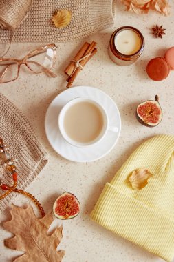 Sonbahar kadınsı yaşam tarzı düz yatış - gündelik süveter, kadın göz bebeği, şapka ve aksesuarlar. Mum, dökülen yapraklar, tarçınlı kurabiyeler arasında estetik bir yaşam tarzı.