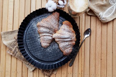 Fransız kruvasanı, dışarıda bir bardak latte ve pamuk süsleme. Sonbahar sıcacık zamanı. Pastel arkaplan.