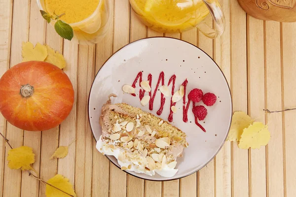 Aesthetic vegan pumpkin cake with healthy sea buckthorn tea. Vegan breakfast at the terrace. Natural healthy lunch among autumn leaves