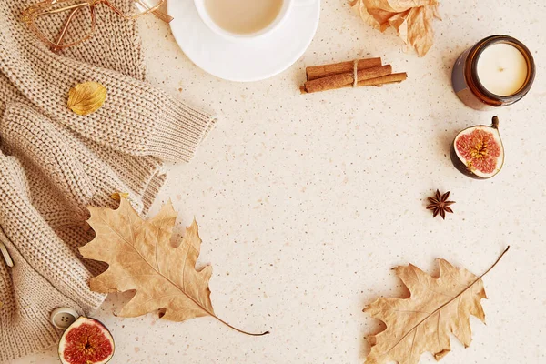Fall feminine background, aesthetic coffee time - sweater, cinnamon sticks, figs, fragrance leaves and coffee cup. Copy space.