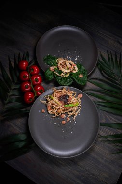 Sade yeşil arka planda Japon mutfağı suşisi. Sezar salatası ve arka planda sağlam bir makarna için karides fotoğrafı.