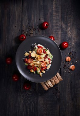 Sade yeşil arka planda Japon mutfağı suşisi. Sezar salatası ve arka planda sağlam bir makarna için karides fotoğrafı.