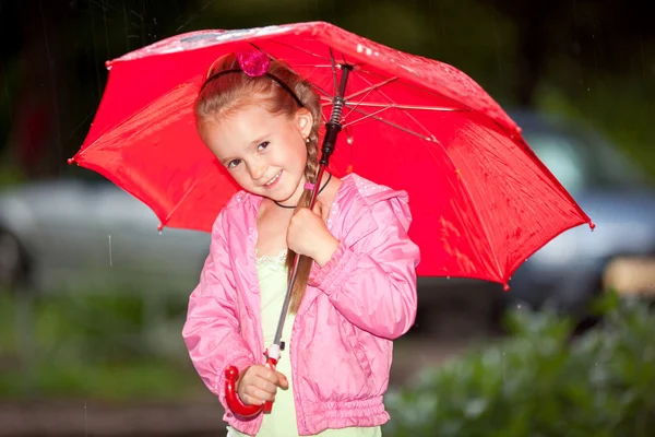 Kleines Mädchen unter einem Regenschirm — Stockfoto