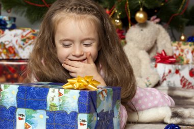 Noel ağacının altında bir hediye ile kız