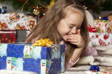 Noel ağacının altında bir hediye ile kız