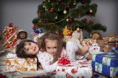 Noel ağacının altında bir hediye ile iki kız