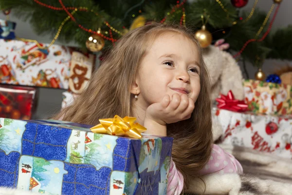 La ragazza con un regalo sotto l'albero di Natale — Foto Stock