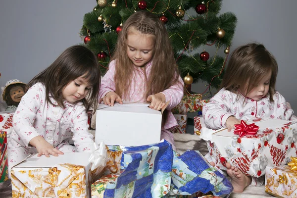 Три дівчини під ялинкою з подарунками — стокове фото
