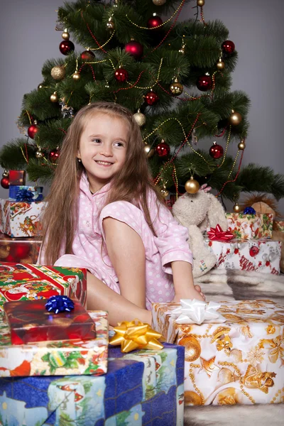 The girl with a gift under the Christmas tree — Stock Photo, Image