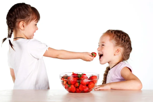 Two little girls with a full bowl of strawberries — Stock Photo, Image