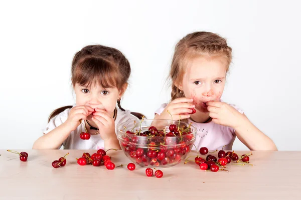 Dvě malé holčičky s plnou misku cherry — Stock fotografie