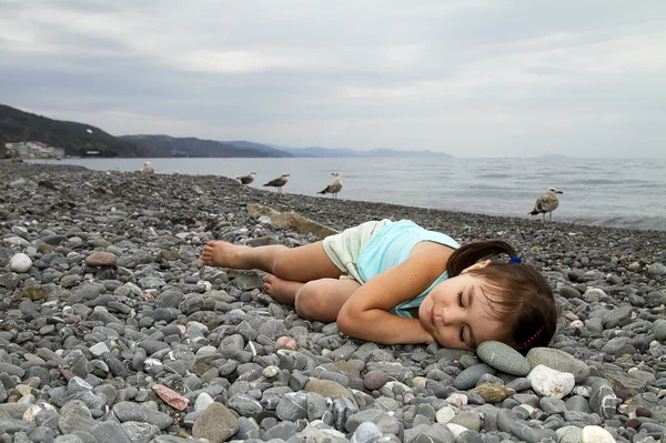 Schattig meisje in slaap op de kust — Stockfoto