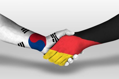 Handshake between germany and south korea flags painted on hands, illustration with clipping path.