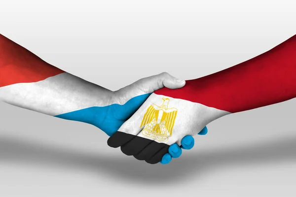 Рукопожатие Между Египетскими Люксембургскими Флагами Раскрашенными Руках Иллюстрация Вырезкой — стоковое фото