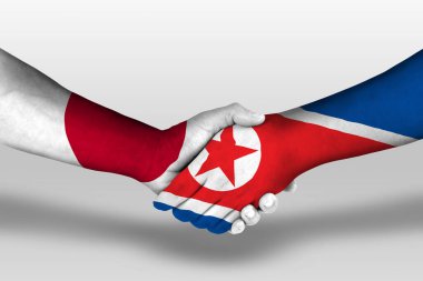 Handshake between north korea and japan flags painted on hands, illustration with clipping path.